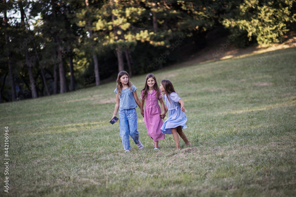 Fototapeta premium Three little girls walking trough nature together.