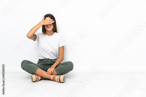 Teenager girl sitting on the floor covering eyes by hands. Do not want to see something