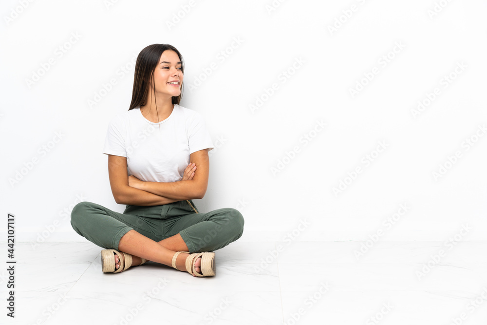 Teenager girl sitting on the floor in lateral position