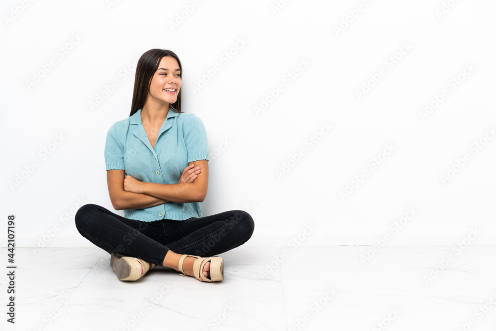 Teenager girl sitting on the floor looking side Teenager girl sitting on the floor looking side