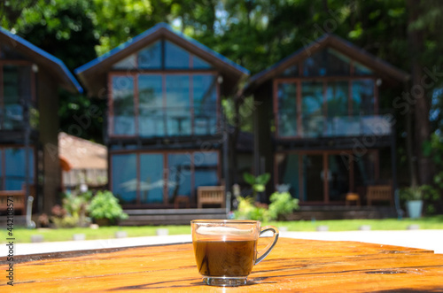 Black coffee on the wooden table, beachside, travel concept , nature light. Thailand