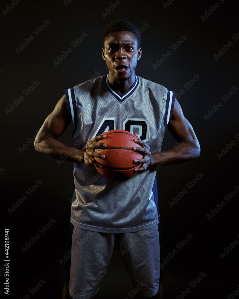 Aggressive basketball player poses with ball