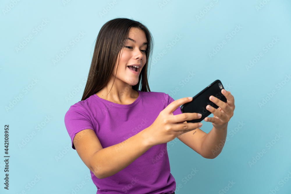 Teenager girl isolated on pink background playing with the mobile phone Teenager girl isolated on pink background playing with the mobile phone