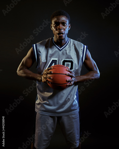 Aggressive basketball player poses with ball © Nomad_Soul
