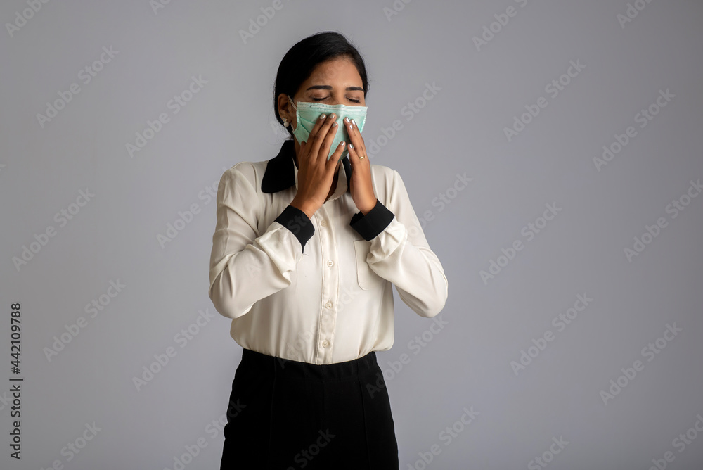 woman wearing a medical mask feeling sick or ill, having a fever. woman wearing a medical mask feeling sick or ill, having a fever.