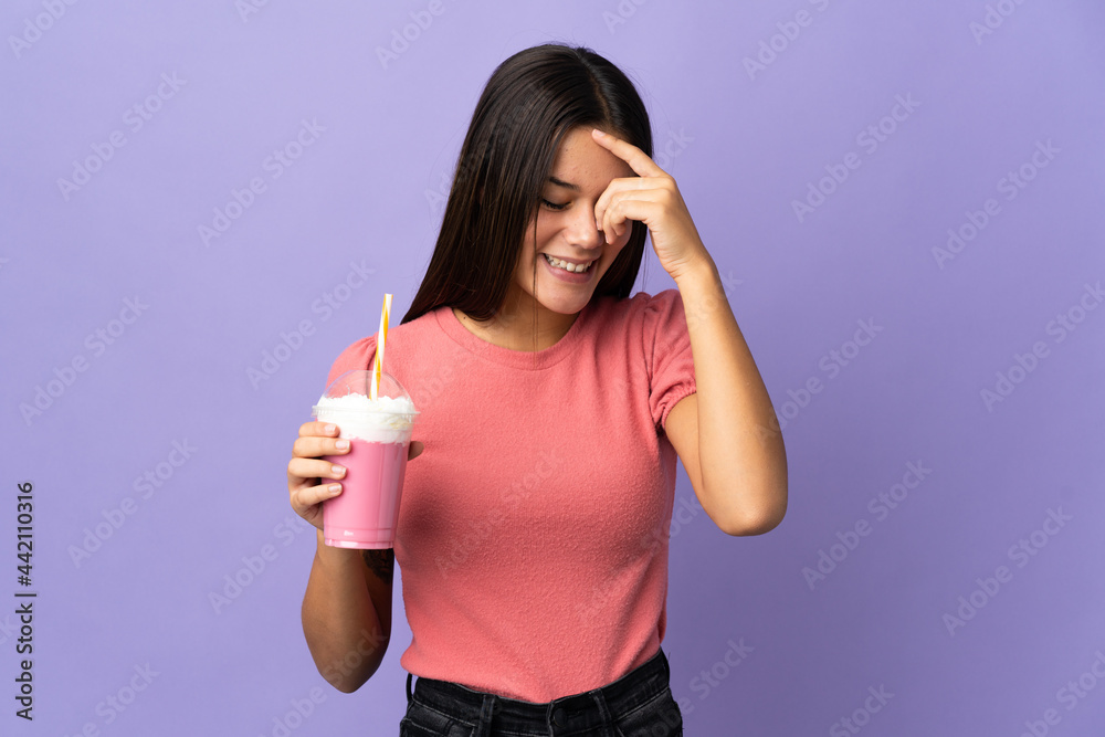 Teenager girl holding a strawberry milkshake laughing Teenager girl holding a strawberry milkshake laughing