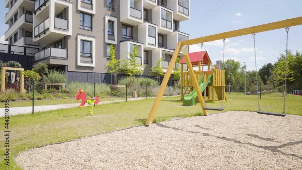 A children's playground in an apartment complex in a suburban area - an apartment building in the background A children's playground in an apartment complex in a suburban area - an apartment building in the background