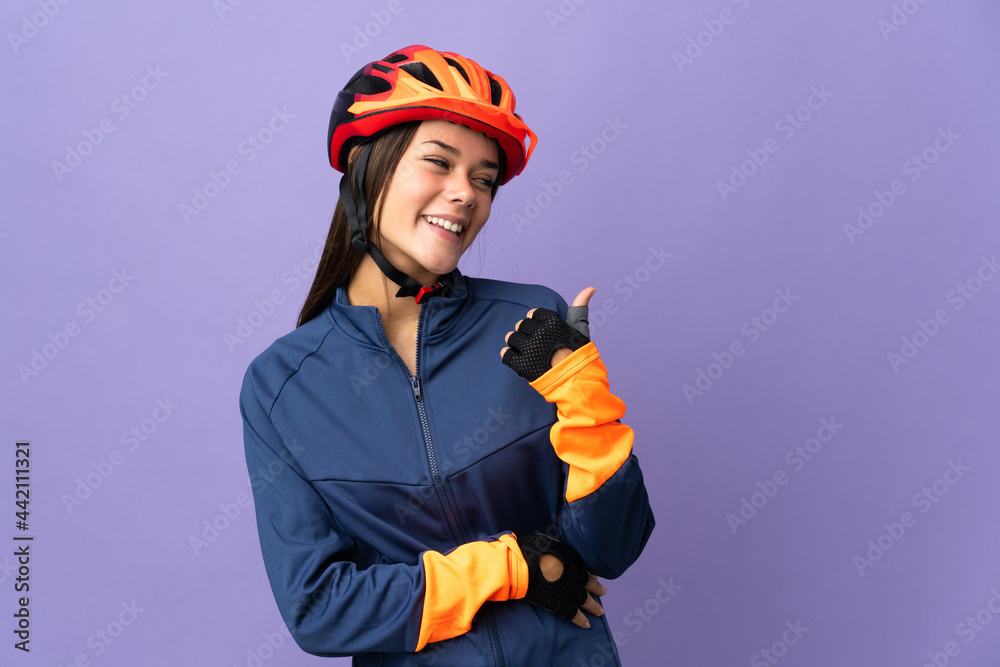 Teenager cyclist girl pointing to the side to present a product Teenager cyclist girl pointing to the side to present a product