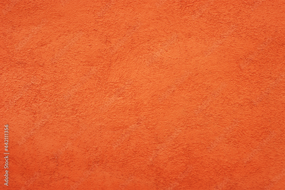 Fototapeta premium Orange wall background with rustic plaster texture.