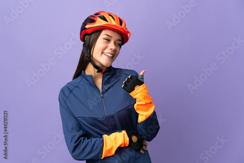 Teenager cyclist girl pointing to the side to present a product