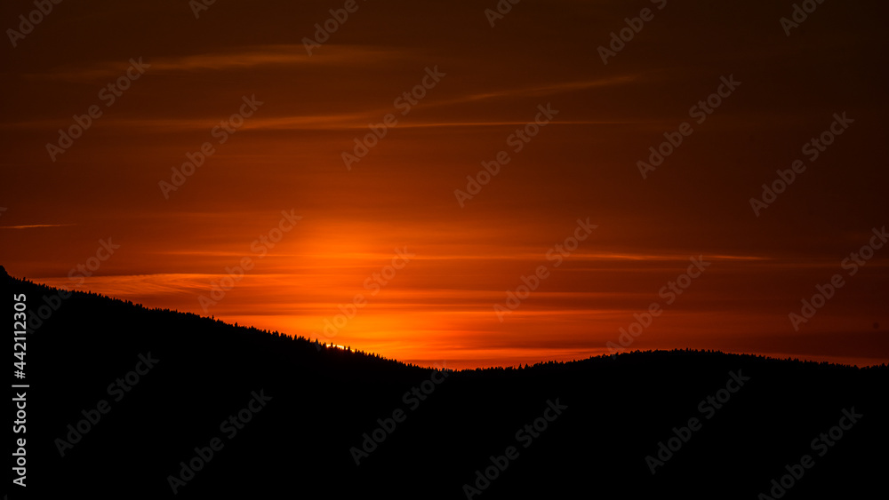 Colorful red evening sky early after sunset. Dusk in mountains.