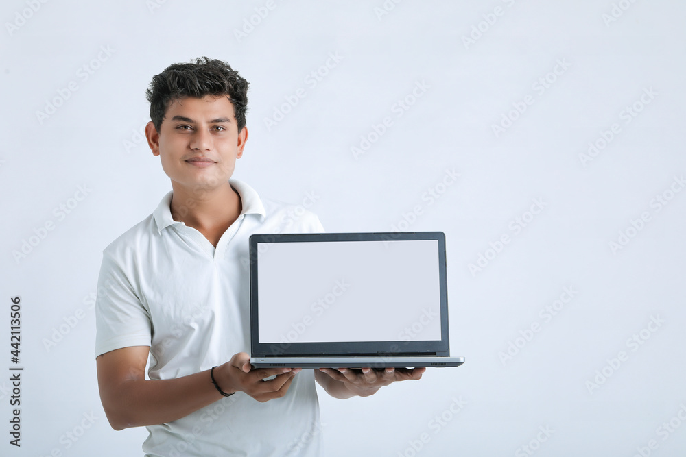 Young indian successful man showing laptop screen over white background.