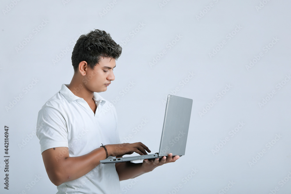 young indian man using laptop.