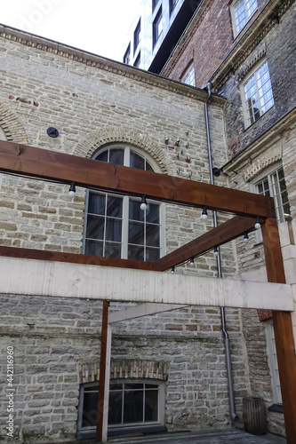 Close up view of an old gray brick building with an arc window in the summertime in Rotermann city - new district of Tallinn. Estonia, Europe. photo