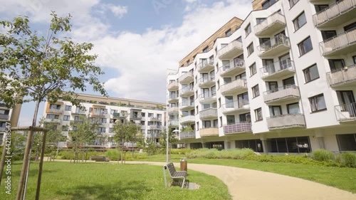 An apartment complex with a walkway and greenery in a suburban area