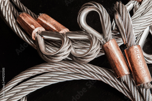 Stainless steel cable, with loops and copper clamps, and a black background, close-up. photo