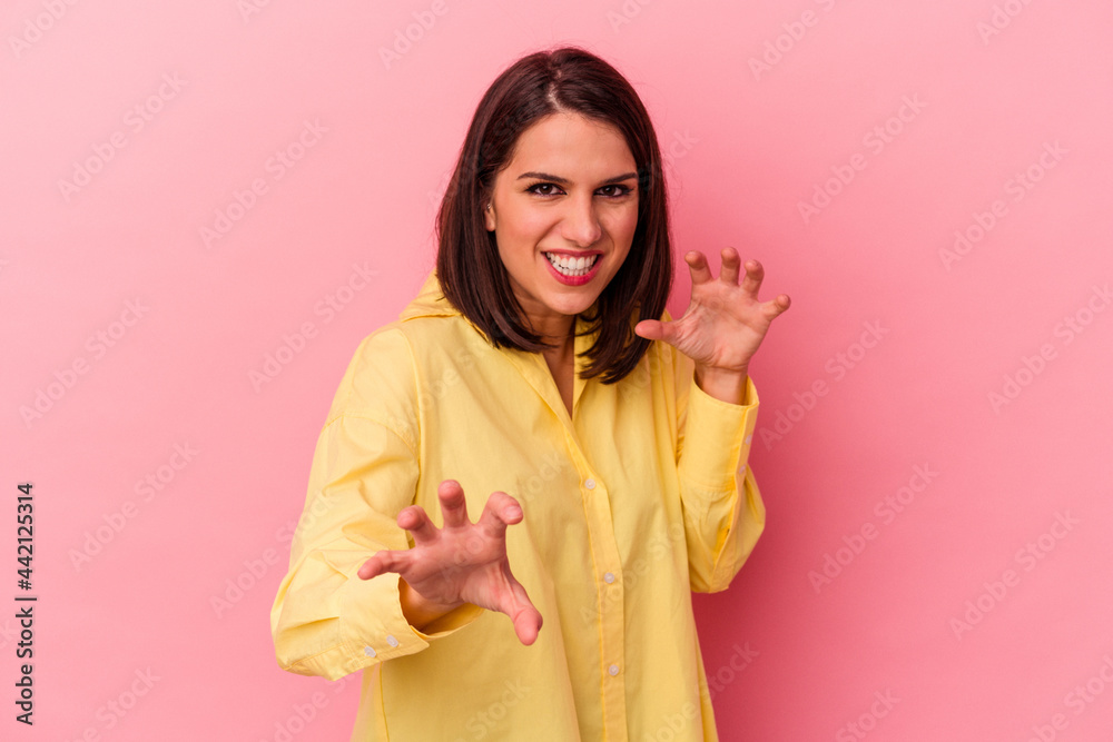 Young caucasian woman isolated on pink background showing claws imitating a cat, aggressive gesture. Young caucasian woman isolated on pink background showing claws imitating a cat, aggressive gesture.