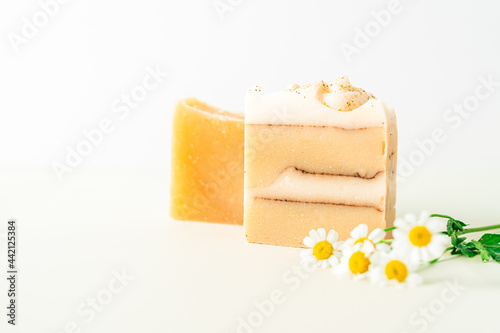 Homemade herbal Soap with chamomile Flowers on white marble background. Zero waste, natural organic bathroom cosmetics. Plastic free life. Ecological skin care, body treatment concept