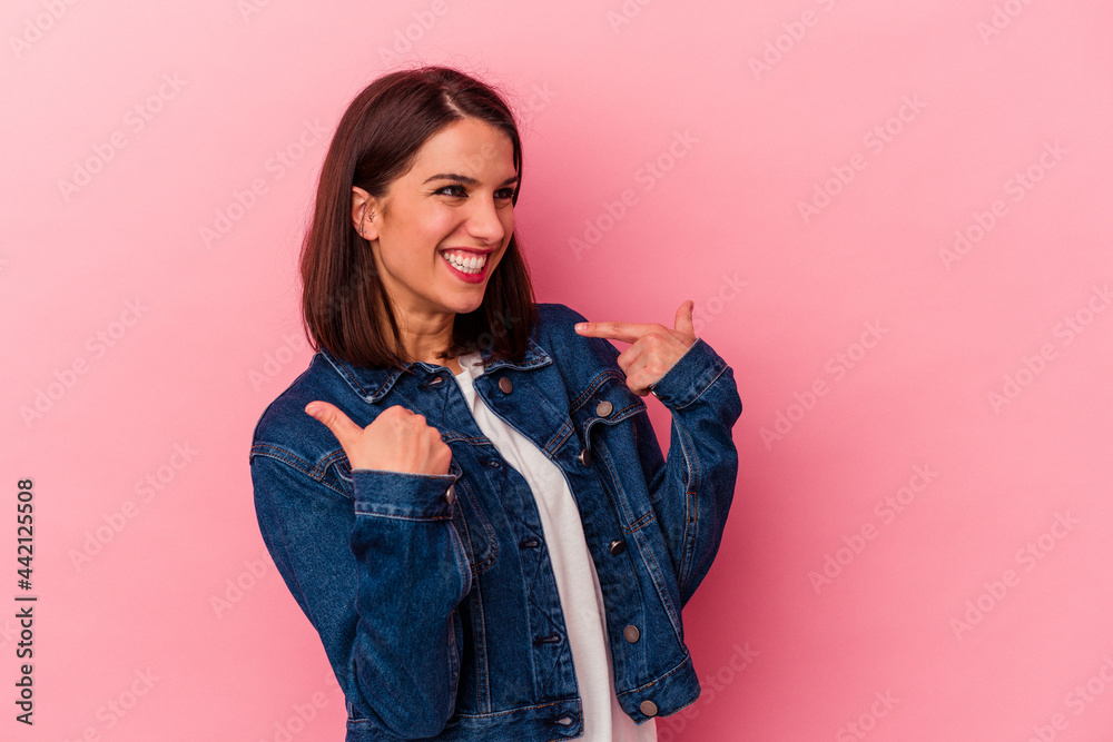 Young caucasian woman isolated on pink background surprised pointing with finger, smiling broadly. Young caucasian woman isolated on pink background surprised pointing with finger, smiling broadly.