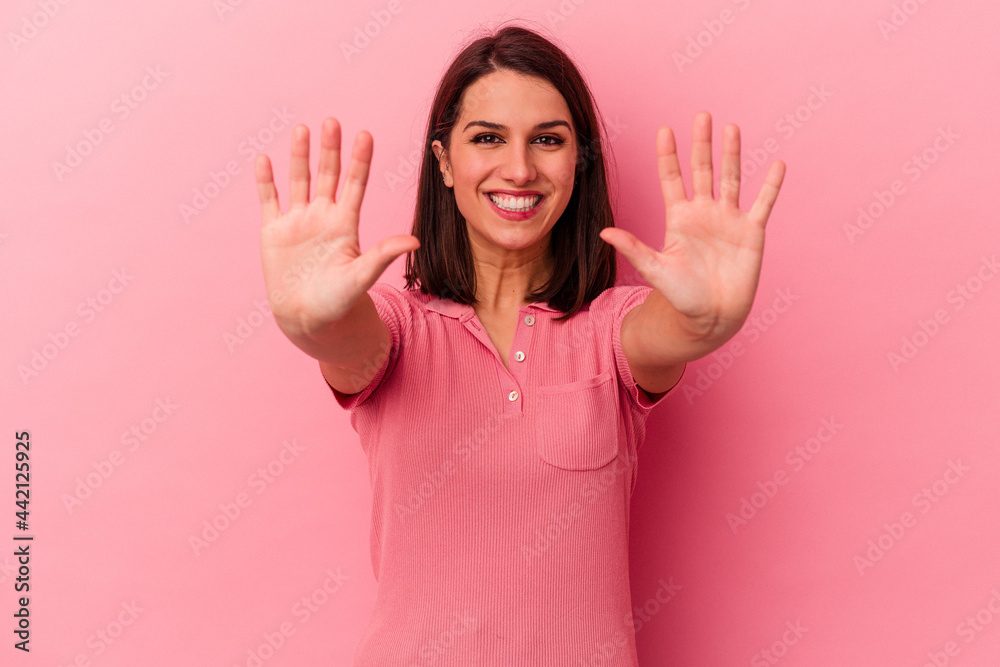 Young caucasian woman isolated on pink background showing number ten with hands. Young caucasian woman isolated on pink background showing number ten with hands.