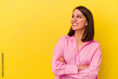 Young caucasian woman isolated on yellow background smiling confident with crossed arms.