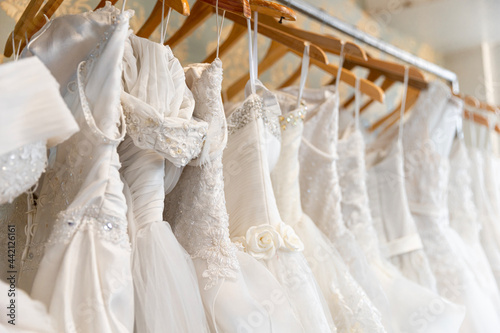 white wedding dress hanging on hangers