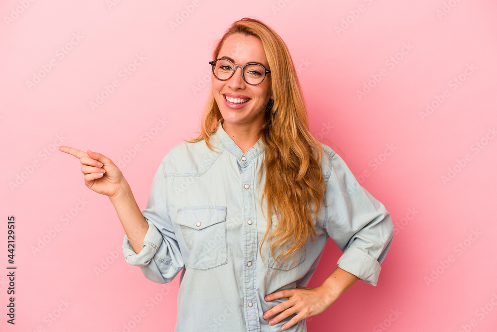 Caucasian blonde woman isolated on pink background smiling cheerfully pointing with forefinger away. Caucasian blonde woman isolated on pink background smiling cheerfully pointing with forefinger away.