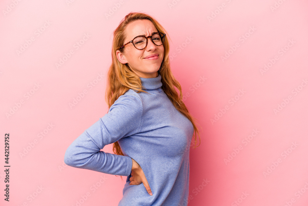 Caucasian blonde woman isolated on pink background suffering a back pain.
