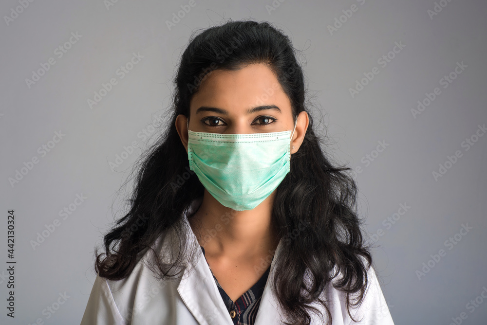 Closeup portrait of a young girl or woman doctor wearing a medical or surgical mask