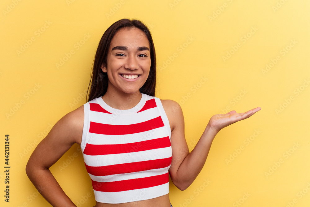 Young mixed race woman isolated on yellow background showing a welcome expression. Young mixed race woman isolated on yellow background showing a welcome expression.