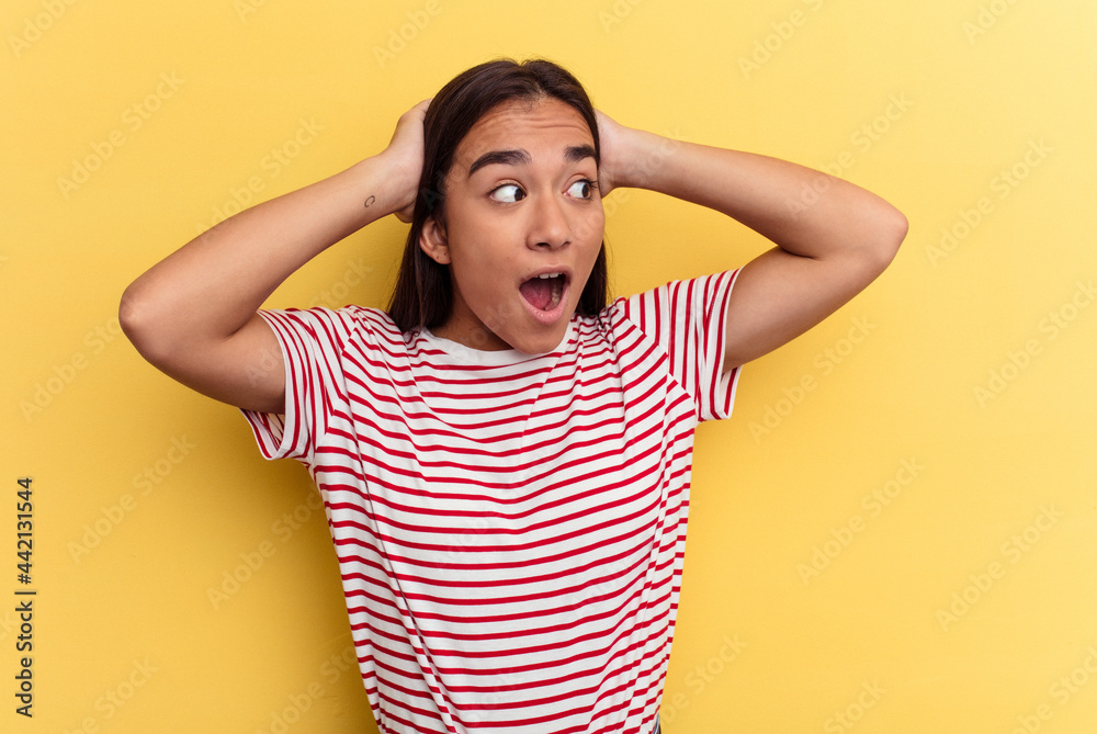 Young mixed race woman isolated on yellow background screaming, very excited, passionate, satisfied with something. Young mixed race woman isolated on yellow background screaming, very excited, passionate, satisfied with something.