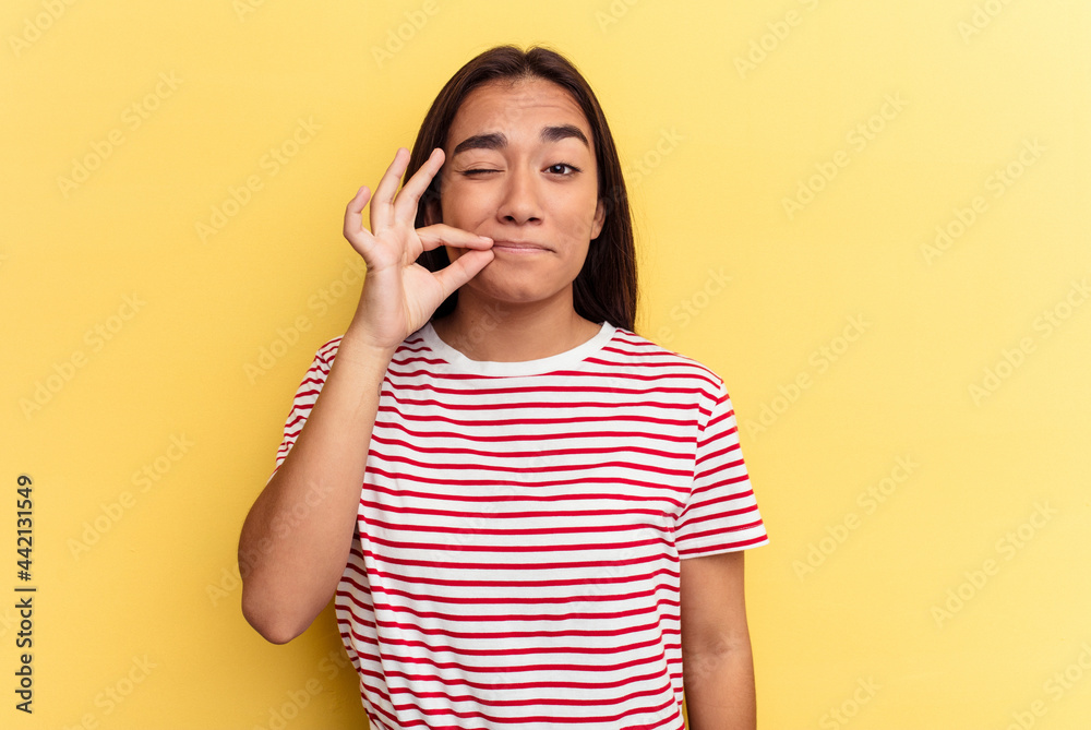 Young mixed race woman isolated on yellow background with fingers on lips keeping a secret. Young mixed race woman isolated on yellow background with fingers on lips keeping a secret.