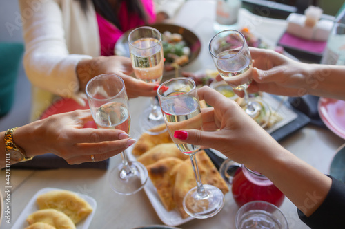 Clinking glasses with alcohol and toasting, party.