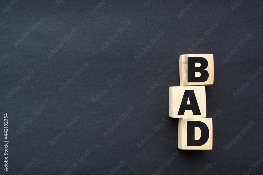 Bad word on wooden blocks on black background. Something negative concept top view. Bad word on wooden blocks on black background. Something negative concept top view.