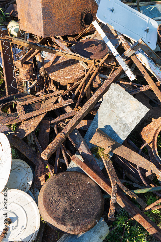 Household scrap metal lies in a mess in a landfill. There are pans, parts of household appliances, kitchen utensils and metal structures. Background. Household scrap metal lies in a mess in a landfill. There are pans, parts of household appliances, kitchen utensils and metal structures. Background.