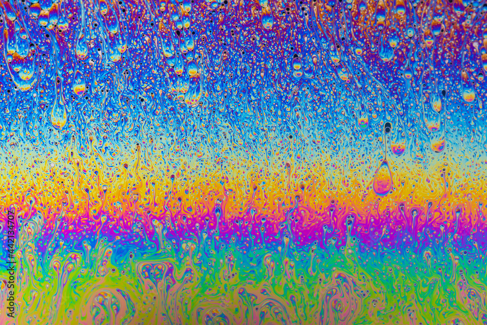 Fluid soap bubble psychedelic colorful abstract art. Surreal patterns with rainbows and waves of color in motion.