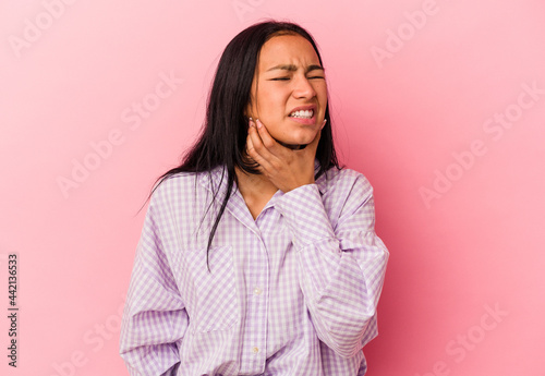 Young Venezuelan woman isolated on pink background having a strong teeth pain, molar ache. © Asier