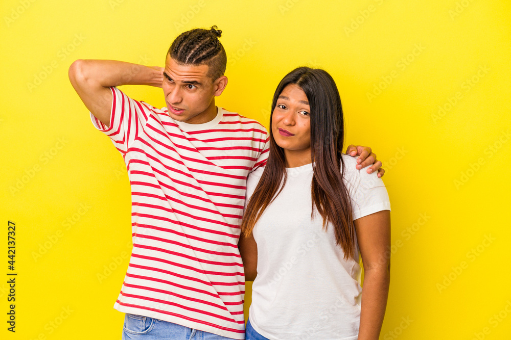 Young latin couple isolated on yellow background touching back of head, thinking and making a choice. Young latin couple isolated on yellow background touching back of head, thinking and making a choice.