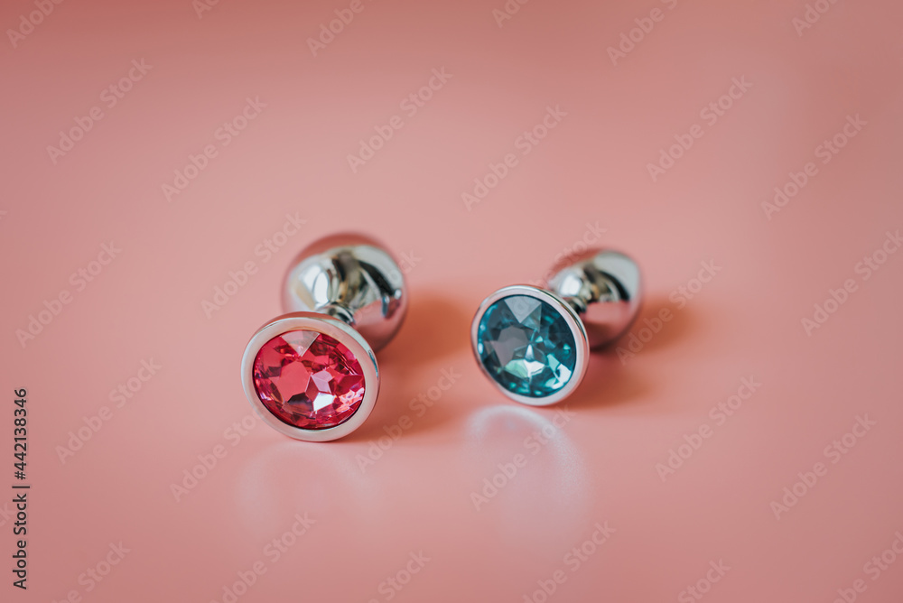 Two metal butt plugs on a blue creative background. Two metal butt plugs on a blue creative background.