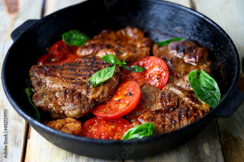 Appetizing juicy grilled steak with grilled vegetables in a pan. Close-up.