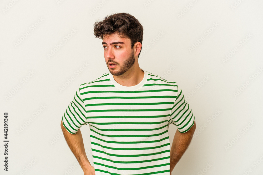 Fototapeta premium Young caucasian man isolated on white background confused, feels doubtful and unsure.