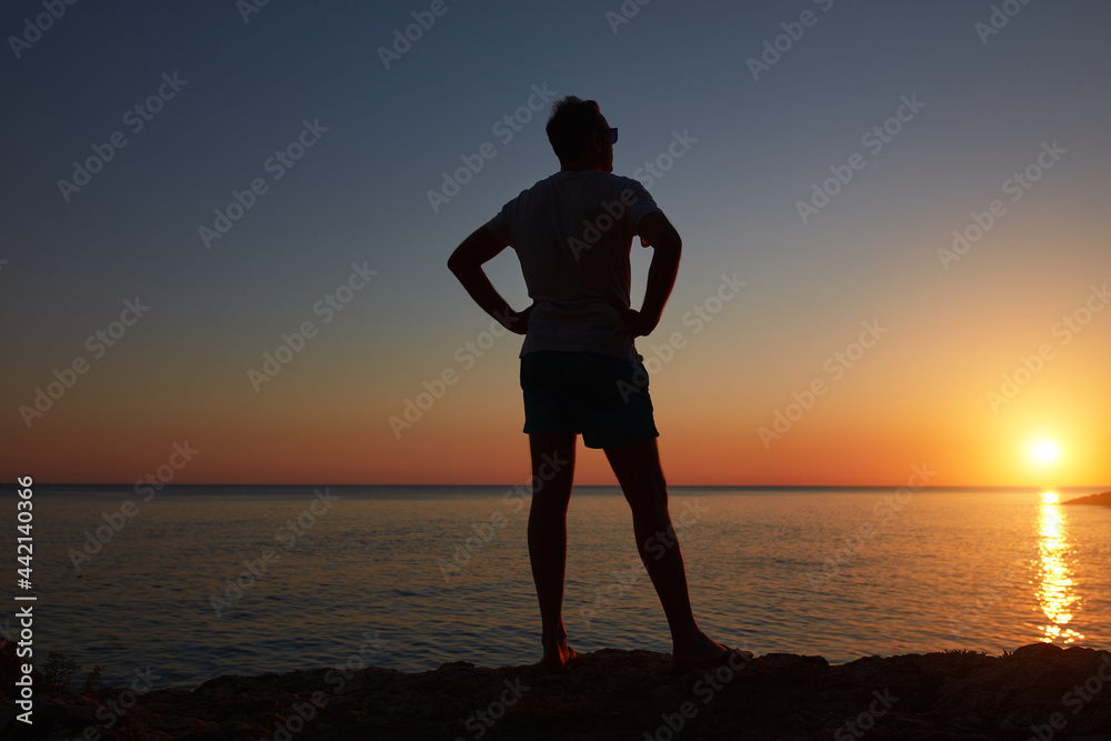 Silhouette of a man watching sunset over distant horizon. Silhouette of a man watching sunset over distant horizon.