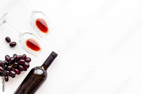 Two glasses of red wine with bottle and grape