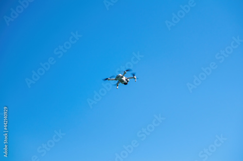 Professional drone equipped with 4K video camera flying in sky.