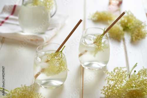 Two glasses with homemade elder flower lemonade with paper straws