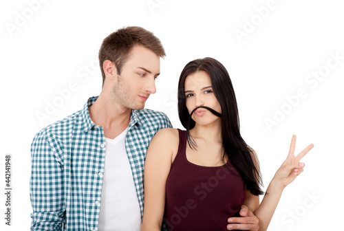 Beautiful young couple bonding to each other and smiling while making a fake mustaches from her hair