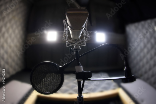 Close-Up Of Microphone and pop filter on acoustic foam panel background in radio station broadcasting studio with copy space