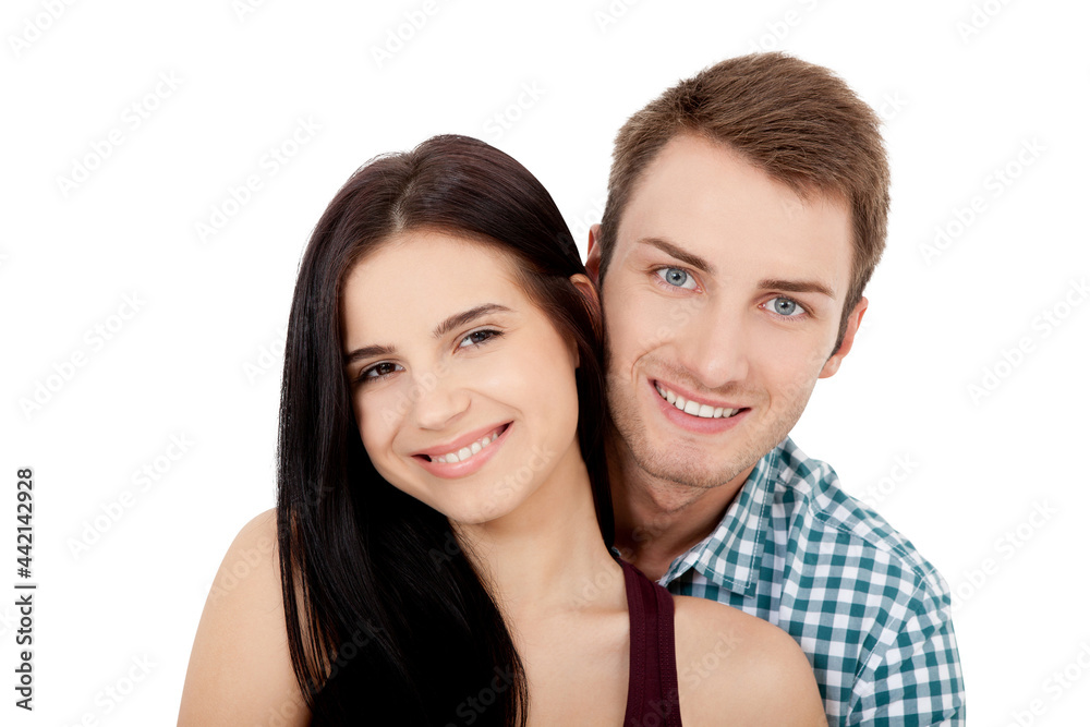 Happy young couple with white perfect smile in summer clothing embracing and looking camera on white background Happy young couple with white perfect smile in summer clothing embracing and looking camera on white background