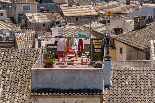 Houses with traditional roof tiles. Detail of the beautiful old town in Arta, Majorca, Spain. Travel scenic. Typical mediterranean cityscape and culture. Drying clothes on a clothesline outdoors. photo
