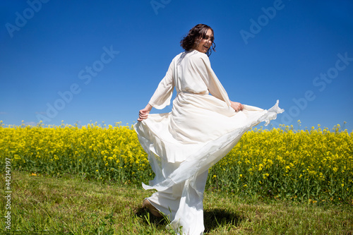 Beautiful Woman in white dress on Rape Field. Yellow Field. rapeseed plantation. Canola Field. Girl In Field.